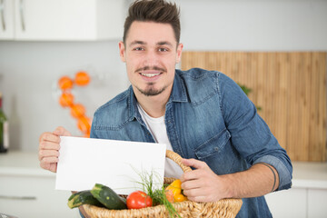 handsome man holding sheet of paper in kitchen