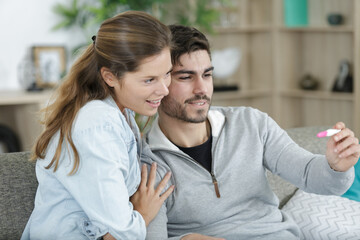 happy couple checking pregnancy test