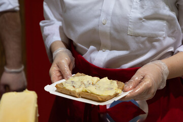 delicious wheel of raclette cheese has been heated on cutting edge.