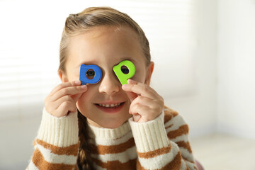 Learning alphabet. Little girl closing eyes with magnetic letters P indoors