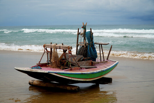 Single Jangada fishing boat, typical for the northeast of Brazil, with furled sails under a cloudy sky on the Atlantic coast near the village of Prainha Aquiraz, state of Ceara, Brazil.