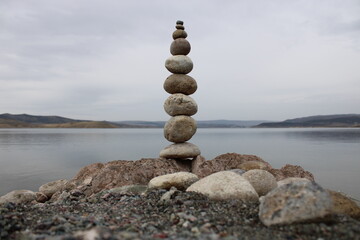 stack of stones on the beach. Various stones top view on the beach. Stone Tower, Land Art, Installation, Stones. stones in balance. Mindfulness themed photo.