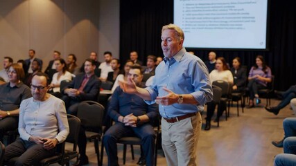 corporate training workshop with professionals in casual attire listening to speaker on stage