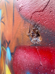 Bullet hole on a graffiti sprayed wall in Colombia