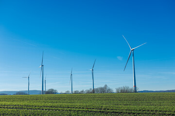 Wind energy generation. Electricity is generated by a wind turbine against a blue sky. Sustainable...