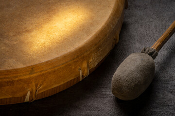 backlit, handmade, native American style, shaman frame drum covered by goat skin with a beater