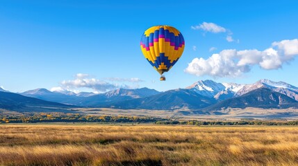 Obraz premium Hot air balloon flight over autumnal valley, snow-capped mountains. Travel, tourism photo