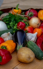 Fresh Organic Vegetables in Paper Bag on Wooden Background