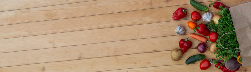 Fresh Organic Vegetables in Paper Bag on Wooden Background