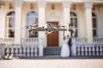A quadcopter flies in an open area during video recording. Video recording from the air.