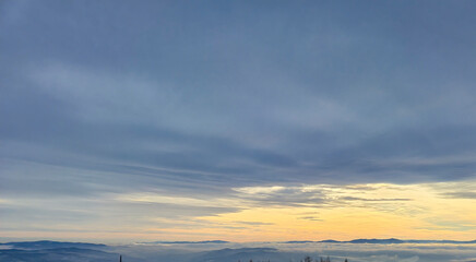 Scenic view of mountains under a vast sky during sunset, showcasing vibrant colors and serene atmosphere, ideal for travel and nature themes.