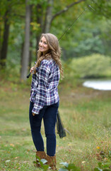Beautiful young woman in flannel shirt with fishing pole - country girl gone fishing'
