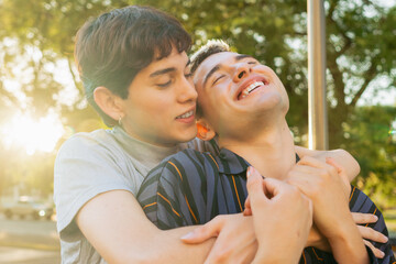 gay couple of young latin men cuddling outside, with trust and love
