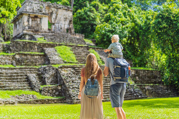 Mom, dad and baby son exploring the ancient pyramids of Palenque, Mexico, surrounded by dense jungle. Cultural heritage and adventure travel concept