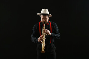 Professional musician playing soprano saxophone on black background