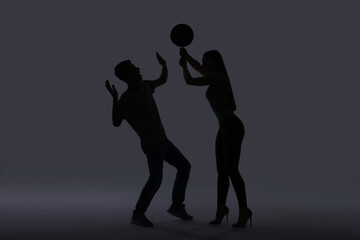 Domestic violence. Silhouette of woman with frying pan threatening her husband on grey background