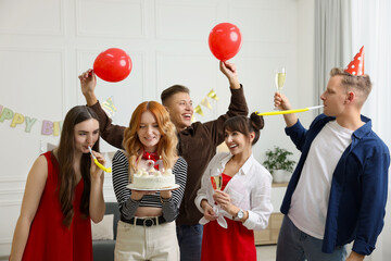 21st birthday. Group of happy friends with tasty cake having coming of age party at home