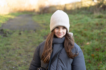 Little cute warmly dressed girl in hat outdoors. Concept of active healthy child outdoors