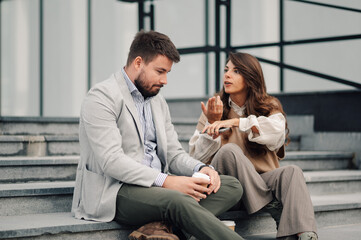 Business people having heated discussion about work on stairs outside office building