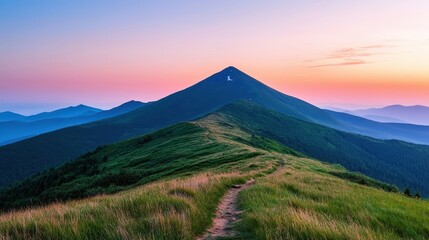 Obraz premium A serene mountain landscape at sunrise, featuring a winding path leading to a peak surrounded by lush greenery and misty hills in the background.