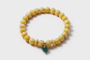 Obraz premium A yellow beaded bracelet with a green gemstone charm.