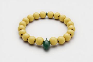 Obraz premium A yellow beaded bracelet with a green bead charm.