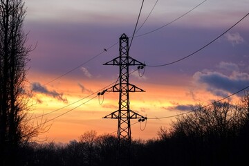 Vue sur un pylône électrique dans la nature en hiver au coucher du soleil