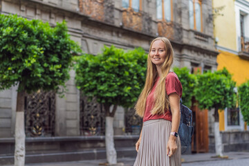 Female tourist walking through the colorful colonial streets of Puebla, Mexico. Travel, cultural exploration, and vibrant architecture concept