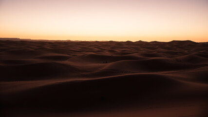 Sand dunes landscape in the sahara desert during sunset with warm colors in merzouga, morocco