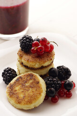 Tasty cheesecakes or pancakes on plate with berries                     