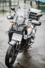 A large black touring motorcycle is covered in snow. The end of the motorcycle season, winter. The inscriptions "Stupid snow, No, WTF" symbolize stubbornness and the desire to continue traveling