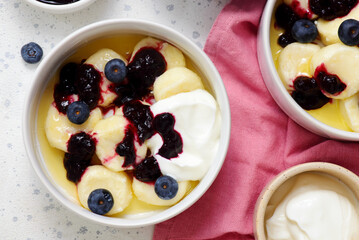 Lazy cottage cheese dumplings with blueberry sauce, sour cream and butter.top veiw