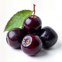 Fresh purple acai berries, leaf arranged on white background. Closeup shot. Healthy food concept. Exotic fruit. Ripe acai berries displayed for commercial use. Fresh berries, leaves. Tropical fruits.