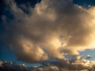 Dark dramatic sunset sky with clouds and sun beams and flare. Nature background for design and sky replacement.