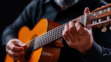 Man playing classical guitar, close-up, dark background, musical performance