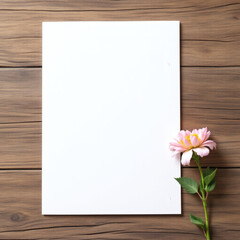 Obraz premium Elegant blank white greeting card with a delicate flower on a rustic wood background, perfect for creative design, DIY projects, and invitations.