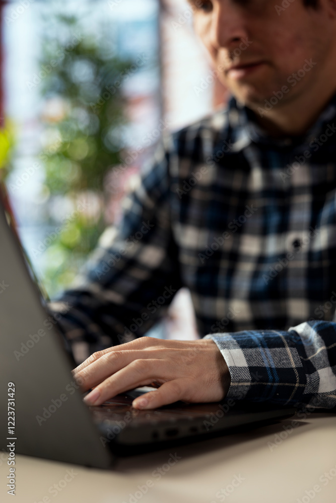 Poster worker at home office desk browses internet on notebook, researching information online. close up of