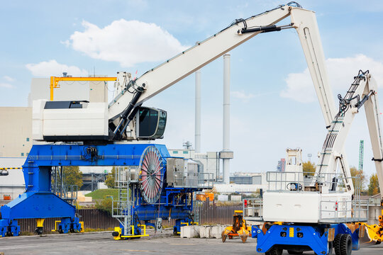 Waste disposal metal recycling site facility gigantic crane stands in scrapyard advanced hydraulic lifting capacity. Heavy machinery modern industrial technology efficient waste recycle management