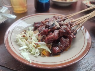 Juicy goat satay skewers served hot on a plate, rich with spices and smoky aroma—perfect for meat lovers craving an authentic Southeast Asian flavor.