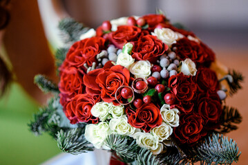 Wedding bouquet with red roses, white flowers, and wedding rings