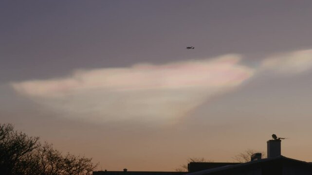Airplane flying across nacreous polar stratospheric clouds Reykjavik Iceland