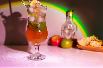 Refreshing summer sangria cocktail with apple, mint, lime and ice on a white table