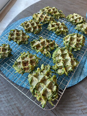 Freshly baked green vegetable zucchini waffles cooling on a wire rack, healthy and delicious homemade, concept of breakfast, snacks, lifestyle.