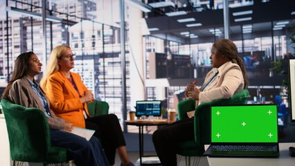 Multiethnic group of women working together next to copy space display, ensuring a successful project in a men dominated business industry. Leaders sharing insight on their plans. Camera B.