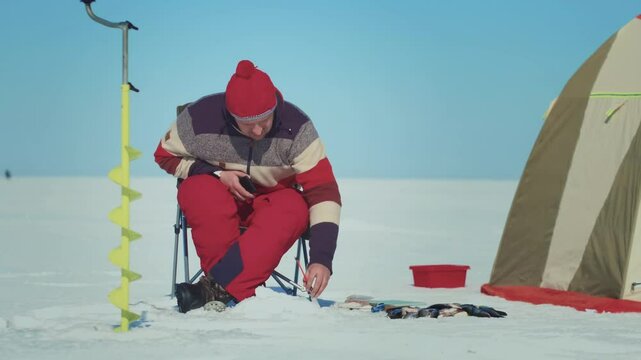 Experience the thrilling and enjoyable activity of winter ice fishing in a snowy landscape