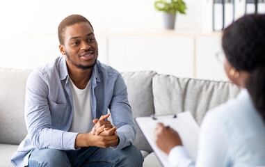 Effective psychotherapy. Young black guy talking to his psychologist, receiving professional help...