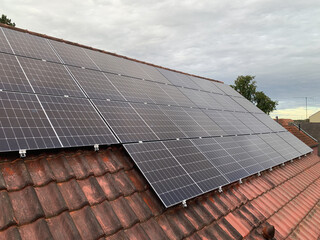 Red Tiled Roof of a Residential House with Installed Solar Panels