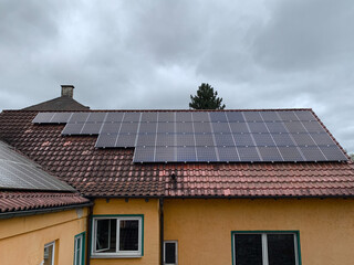 Red Tiled Roof of a Residential House with Installed Solar Panels