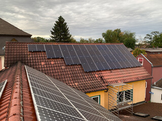 Red Tiled Roof of a Residential House with Installed Solar Panels