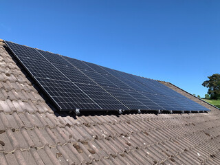 Dark Tiled Roof of a Residential House with Installed Solar Panels